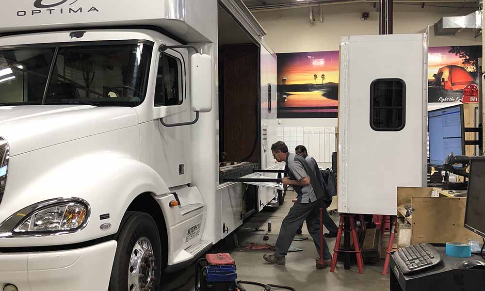 A trailer servicing team works on a vehicle.